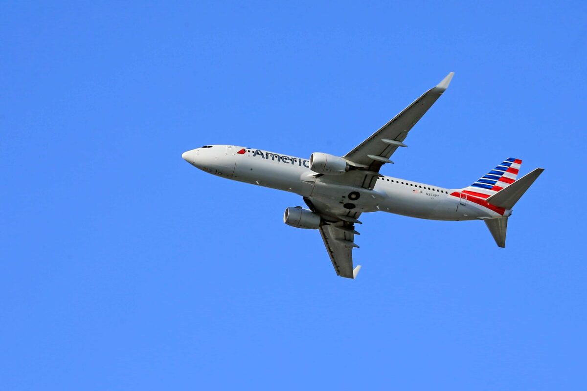 American Airlines aircraft soaring in a clear blue sky, symbolizing the airline’s updated 2025 pet travel policies.